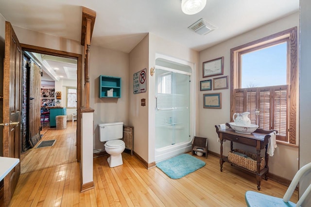 full bathroom with hardwood / wood-style floors, toilet, baseboards, and visible vents