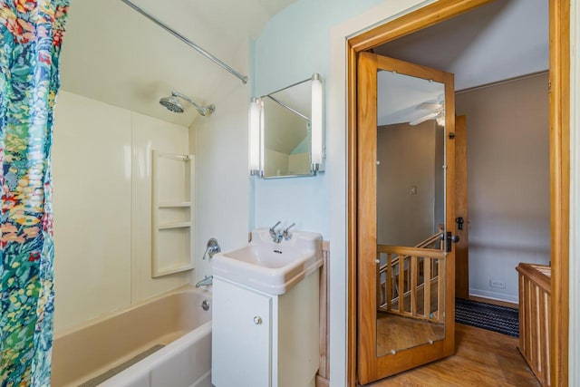 full bath featuring shower / bath combo with shower curtain, wood finished floors, and vanity