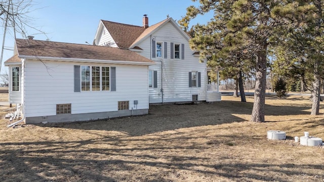 back of house featuring a shingled roof