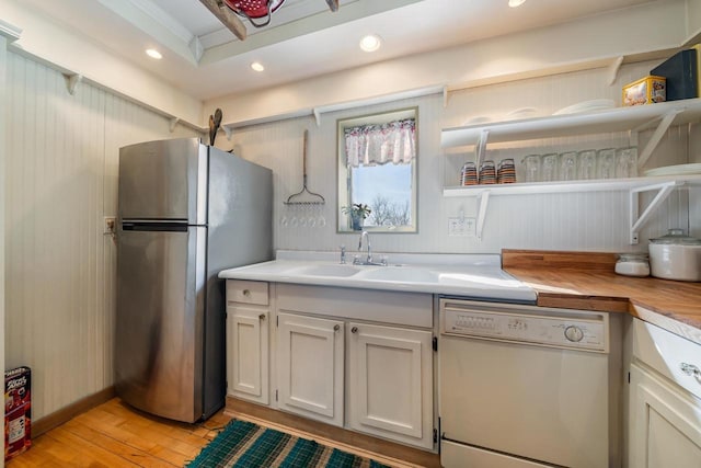 kitchen with light wood-type flooring, recessed lighting, freestanding refrigerator, white dishwasher, and a sink