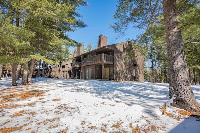 snow covered property featuring a chimney