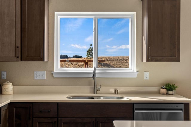 kitchen featuring stainless steel dishwasher, light countertops, dark brown cabinets, and a sink