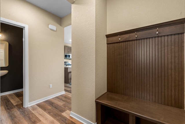 mudroom with a textured wall, baseboards, and wood finished floors