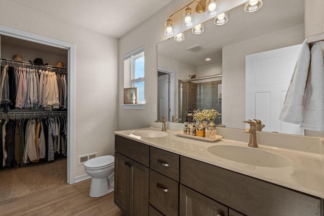 bathroom featuring double vanity, a stall shower, visible vents, and a sink