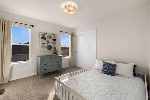 bedroom featuring a closet, visible vents, baseboards, and carpet