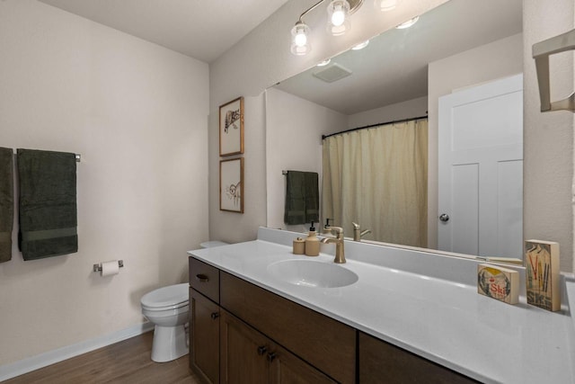 full bathroom featuring toilet, curtained shower, wood finished floors, baseboards, and vanity