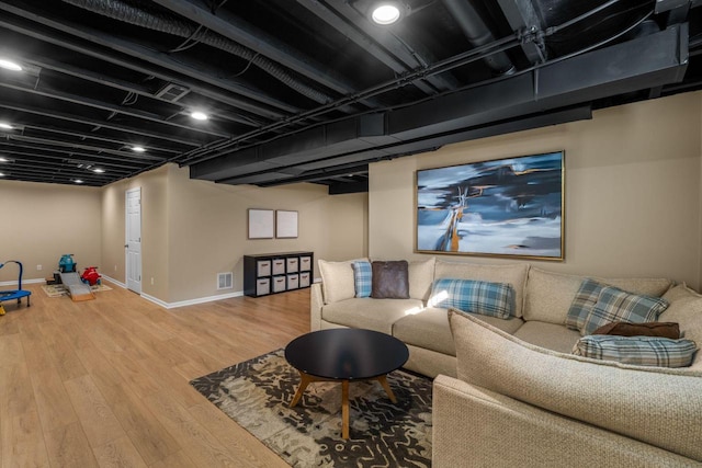 living room featuring wood finished floors, visible vents, and baseboards