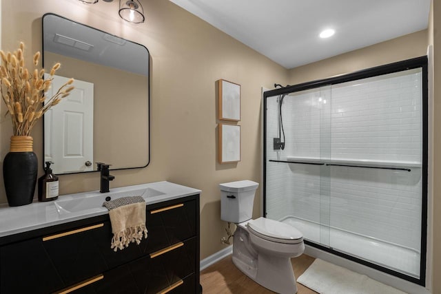 full bath with a shower stall, toilet, vanity, and baseboards