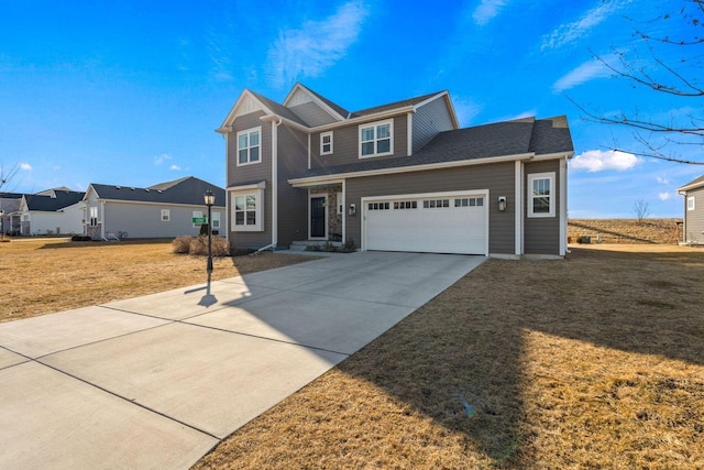 traditional-style house featuring a garage, concrete driveway, and a front yard