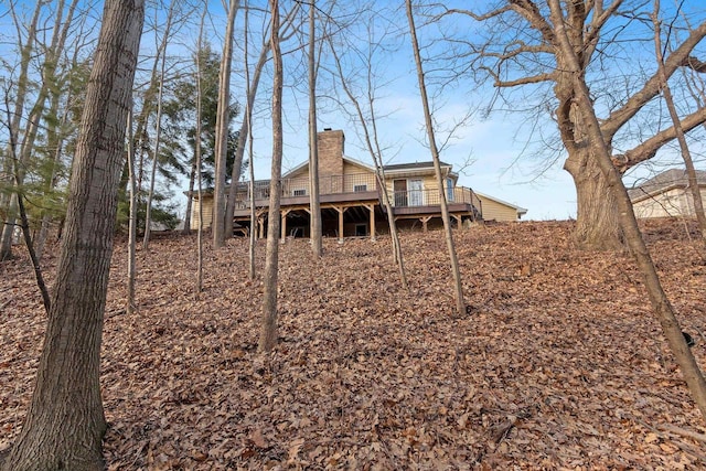 rear view of house featuring a chimney and a deck