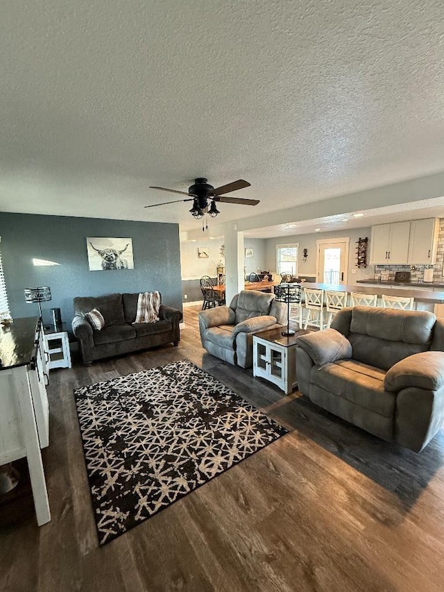 3743 S Milton Shopiere Rd, Janesville, WI 53546 - living room featuring a textured ceiling, dark wood-style floors, and a ceiling fan
