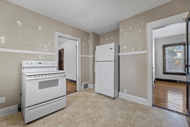 kitchen with visible vents, white appliances, and baseboards