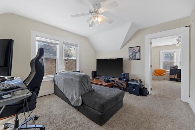 carpeted home office with baseboards, ceiling fan, and vaulted ceiling