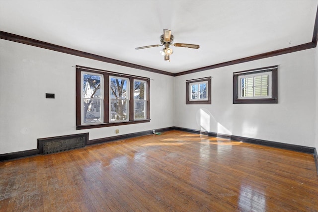 spare room featuring hardwood / wood-style flooring, baseboards, a wealth of natural light, and ornamental molding