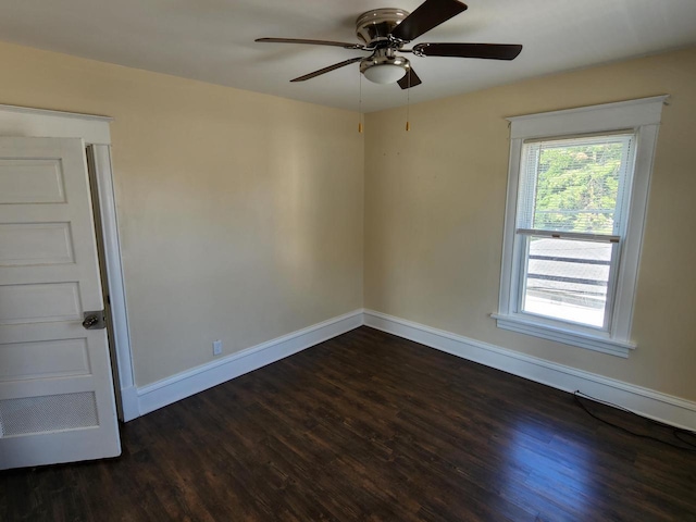 unfurnished room with baseboards, dark wood finished floors, and a ceiling fan