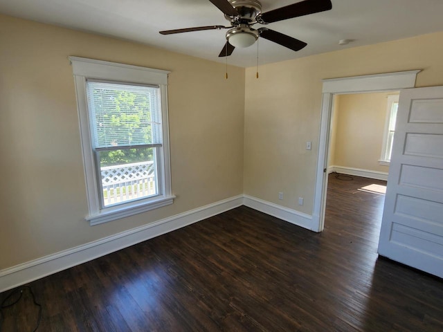 spare room featuring baseboards and wood finished floors