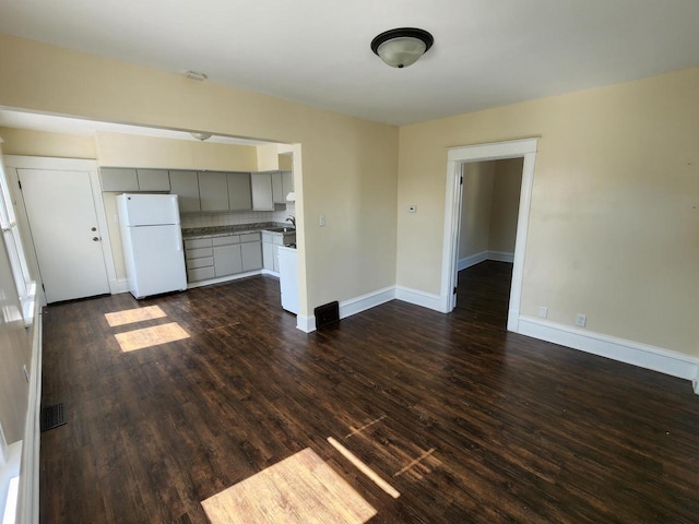 unfurnished living room with dark wood finished floors and baseboards