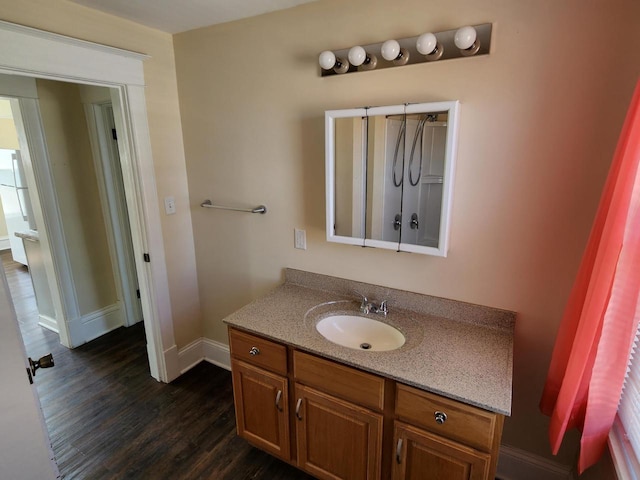 bathroom featuring vanity, baseboards, and wood finished floors