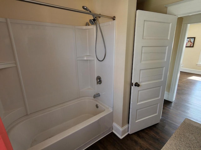 full bath featuring tub / shower combination, baseboards, and wood finished floors