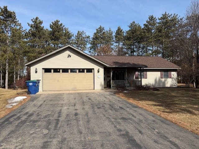 ranch-style home featuring aphalt driveway, an attached garage, a porch, and a front yard