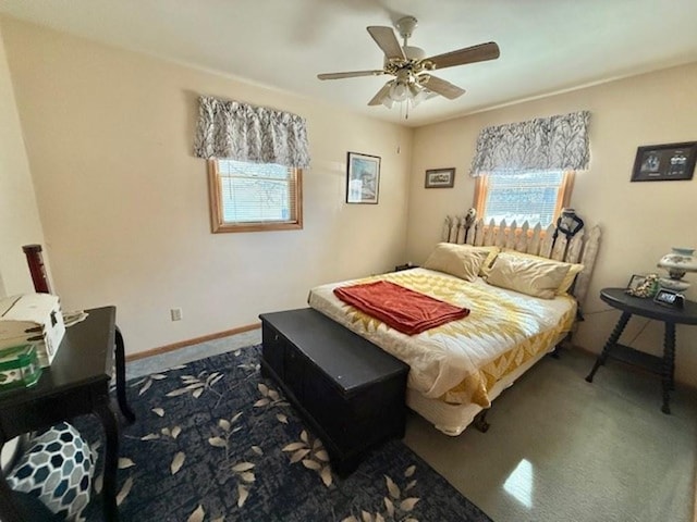 bedroom with multiple windows, a ceiling fan, baseboards, and dark colored carpet