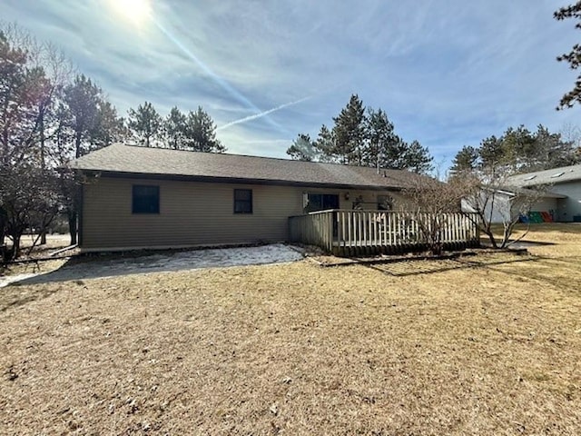 back of property with a lawn and a wooden deck