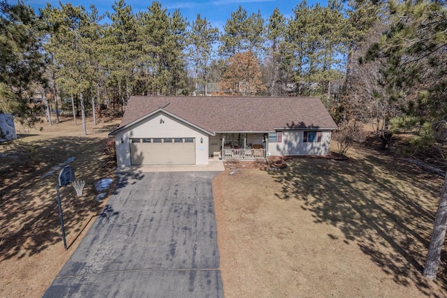 ranch-style home featuring a porch, a garage, driveway, and a shingled roof