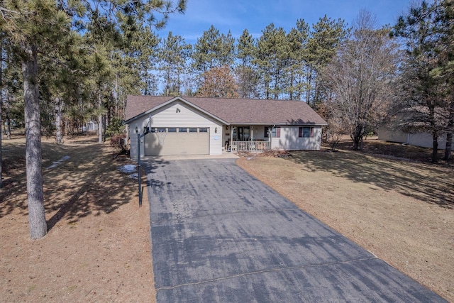 ranch-style house featuring covered porch, driveway, and an attached garage