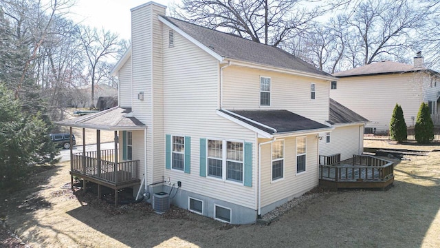 exterior space featuring a chimney, a deck, and a shingled roof