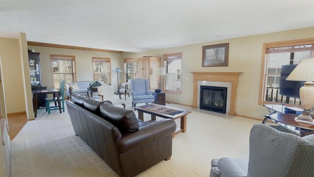 living room featuring a fireplace, baseboards, and light carpet