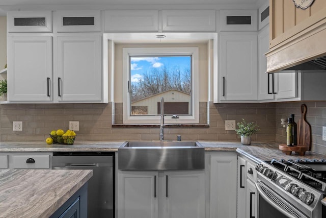 kitchen featuring premium range hood, a sink, stainless steel appliances, white cabinets, and glass insert cabinets