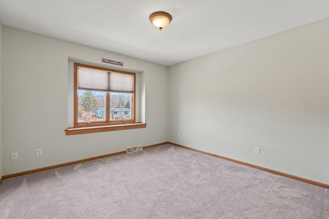 empty room with baseboards, visible vents, and carpet floors