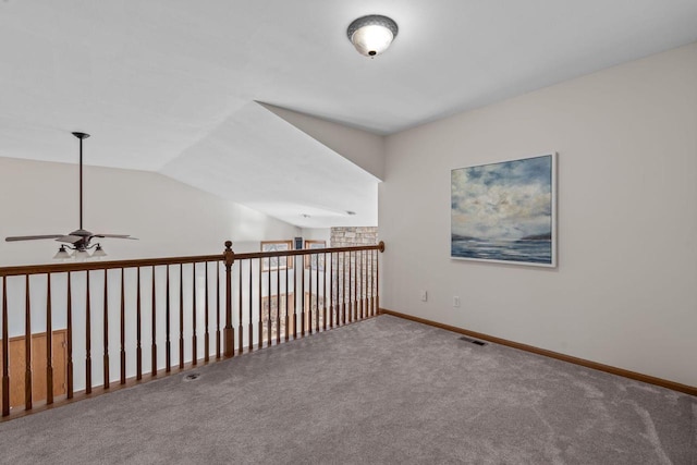 spare room featuring visible vents, carpet flooring, baseboards, and lofted ceiling