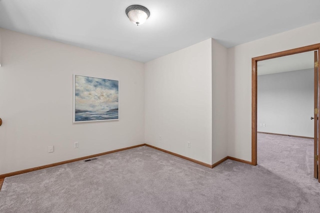 empty room with visible vents, baseboards, and carpet flooring