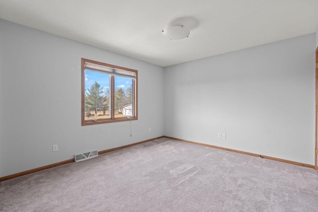 empty room featuring carpet, visible vents, and baseboards