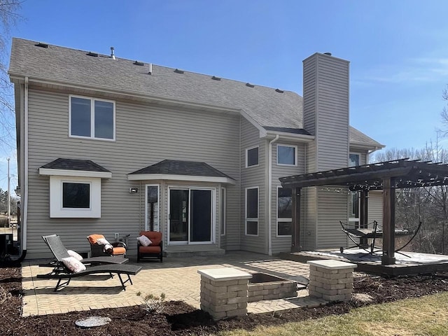 back of property featuring a patio, a pergola, roof with shingles, and a chimney