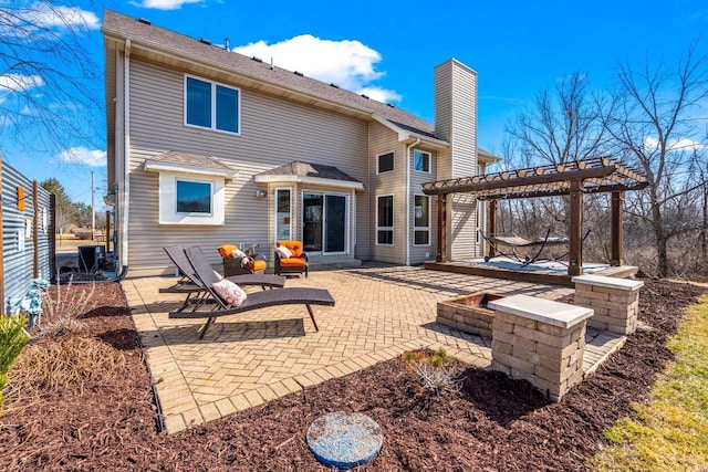 back of house featuring a patio, a chimney, and a pergola