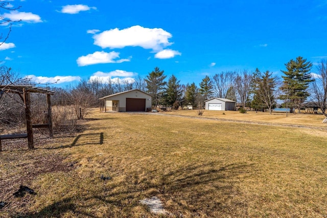 view of yard featuring a detached garage and an outdoor structure