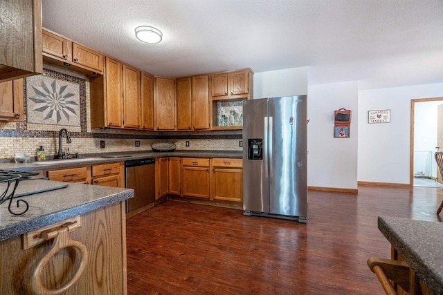 kitchen featuring dark wood finished floors, decorative backsplash, and appliances with stainless steel finishes