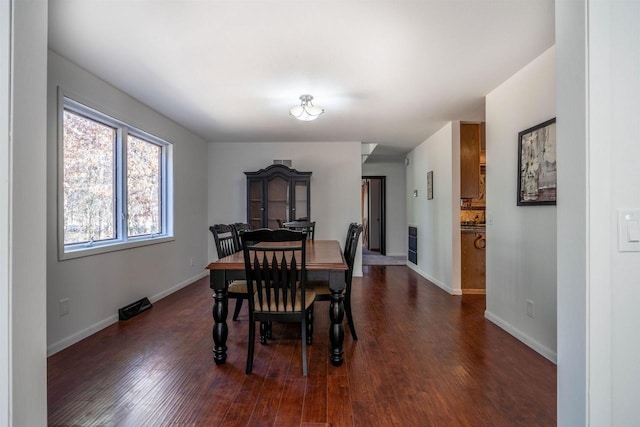 dining room featuring baseboards and dark wood-style floors