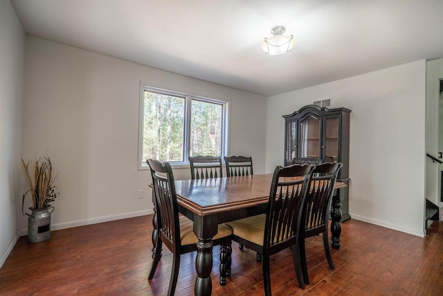 dining room featuring dark wood-type flooring and baseboards