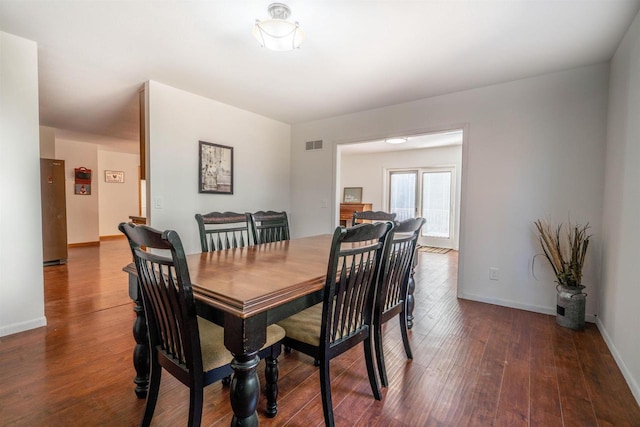 dining room featuring wood finished floors, visible vents, and baseboards