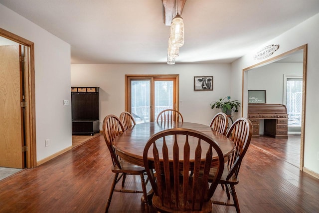 dining space featuring baseboards and wood finished floors