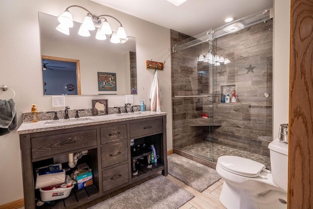 full bath featuring a sink, toilet, double vanity, and a shower stall