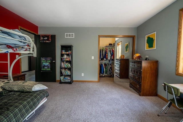 carpeted bedroom featuring visible vents, baseboards, and a closet