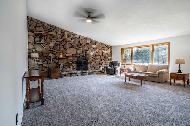 living area featuring a stone fireplace, a ceiling fan, and carpet floors