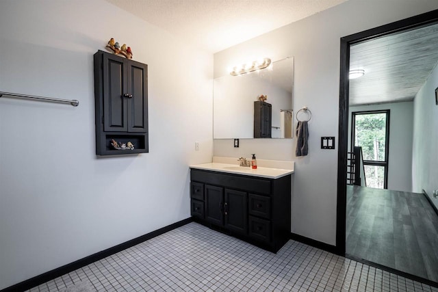 bathroom with vanity, tile patterned floors, baseboards, and a textured ceiling