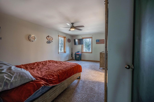 carpeted bedroom featuring baseboards and ceiling fan