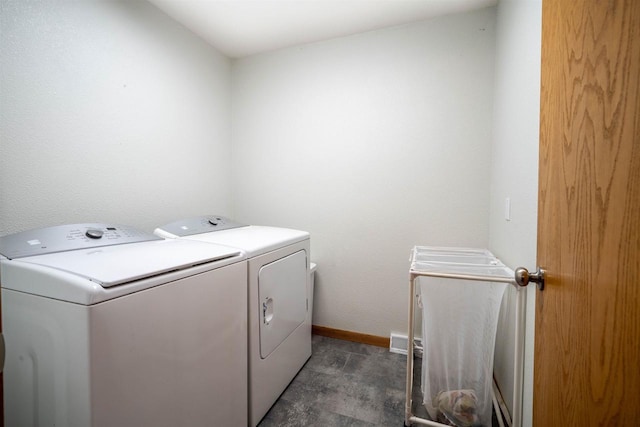 laundry area with baseboards, separate washer and dryer, and laundry area