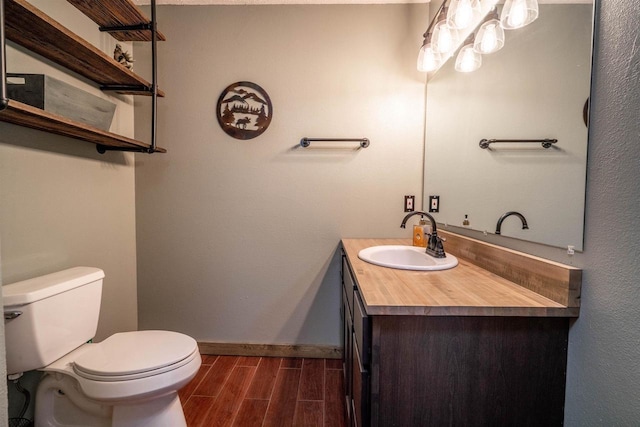 half bath featuring toilet, vanity, baseboards, and wood tiled floor